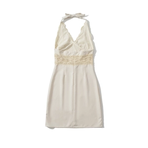 Detail of white halter neck mini dress featuring intricate lace waist inserts
