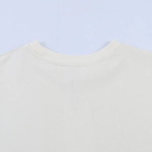 Detailed macro view of the reinforced ribbed neckline and stitching on this cream t-shirt