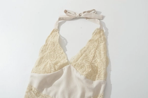 Detail of lace halter neck with tie bow and intricate crochet texture on dress