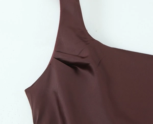 Detail view of dark brown satin dress fabric featuring elegant pleats and smooth texture