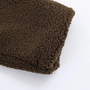 Close-up of deep brown fleece texture and stitching detail on women's long coat sleeve