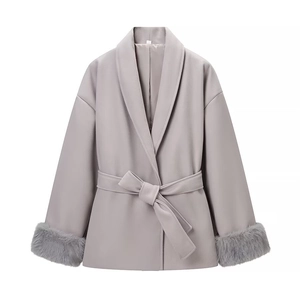 Détail du manteau d'hiver avec poignets en fausse fourrure grise et ceinture nouée chic