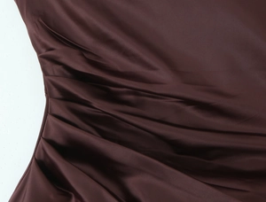 Close-up of ruched dark brown satin fabric detail showing smooth texture and pleated design