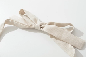 Close-up of the natural cotton-linen fabric bow belt showing detailed fiber texture