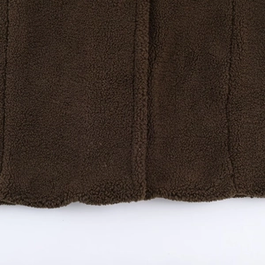Detailed macro shot of dark brown sherpa fleece fabric texture on women's long coat