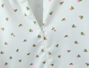 Détail macro de la robe blanche à fleurs avec une fermeture éclair invisible sans couture