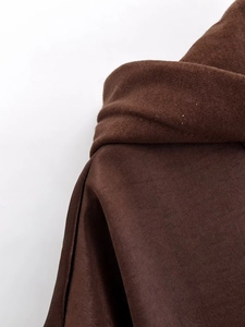 Macro detail of dark brown textured knit fabric and hood seam on winter casual jacket