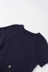 Macro detail of navy knit fabric texture featuring a decorative gold metallic buckle