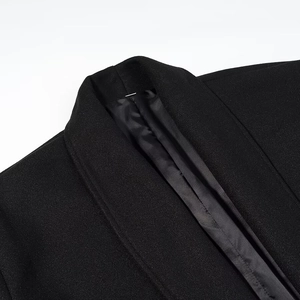 Gros plan d'un manteau noir en laine avec col châle et doublure satinée de qualité