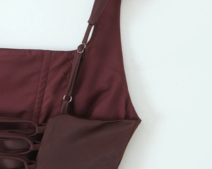 Detail view of burgundy satin dress with adjustable straps and lace-up back design