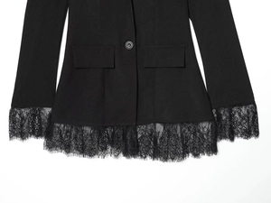 Detailed view of women's black blazer with delicate floral lace trim and single button