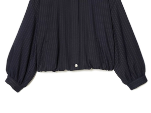 Detail of navy pinstripe bomber jacket with elastic hem and metallic button closure