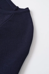 Detailed view of the navy blue ribbed knit texture and round neckline finish