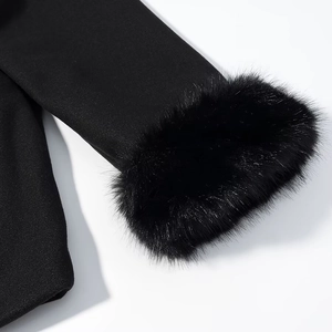 Détail de la manche du manteau d'hiver avec garniture en fausse fourrure noire et tissu fin