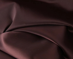 Macro detail of dark brown satin fabric with smooth texture and soft pearly luster