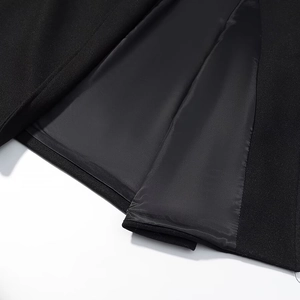 Gros plan sur l'ourlet du manteau en laine, texture noire et doublure en satin lisse