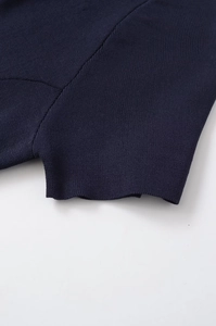 Detailed close-up showing the premium dark blue knit fabric and hem of the garment