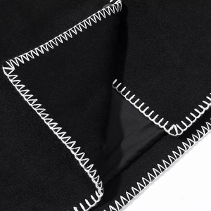 Close-up of black wool-like jacket with decorative white contrast stitching and soft lining