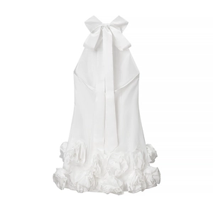 Detail of white halter dress featuring a large satin bow and 3D chiffon floral hemline
