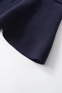 Detail of navy blue knit fabric showing tight weave texture and smooth finished edges