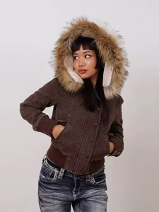 Detail of dark brown corduroy texture and plush oversized faux fur collar on the jacket