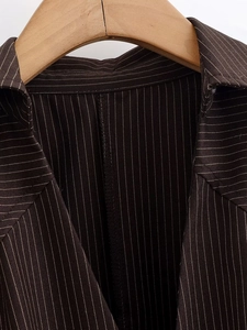 Detail of a brown striped shirt collar with fine white stripes and premium stitching