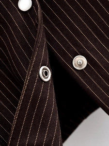 Detail of pinstripe fabric texture with polished silver metal snap buttons on shirt