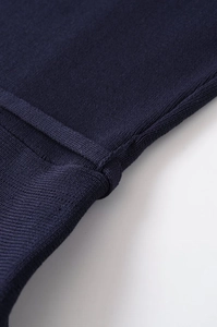 Detailed close-up of dark blue ribbed knit fabric with precise seams and high quality texture