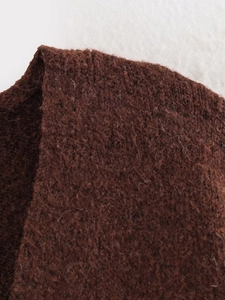 Close-up of dark brown chunky knit texture with fuzzy wool blend fibers and soft ribbed pattern