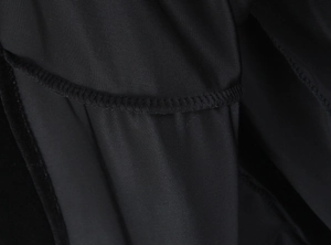 Detail shot of black fabric texture with fine plain weave and precise edge stitching