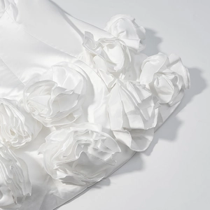 Detail of white satin dress featuring intricate 3D handcrafted silk rose floral appliques