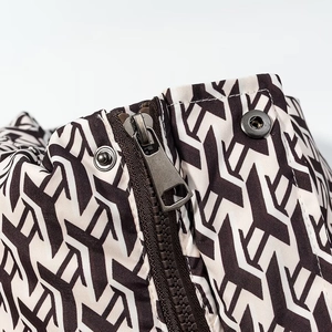 Macro detail of high-quality geometric pattern jacket with metallic zipper and snap buttons