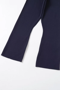 Detailed close-up of navy blue knit trousers showing the fine texture and straight hem edge