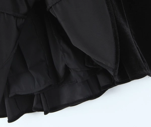 Macro detail of black velvet fabric showing stitched hem and smooth lining layers