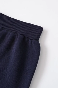 Detail of navy knit pants featuring a high-elastic wide ribbed waistband and texture