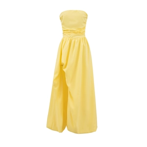 Detail view of the yellow strapless dress with waist pleats and a high slit hemline