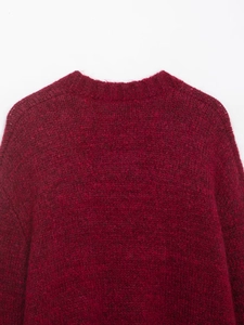 Close-up detail of dark red knit cardigan showing fluffy wool texture and round neckline