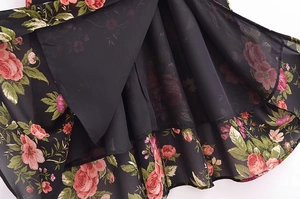 Detail of floral chiffon dress hem with black inner lining and pink rose pattern
