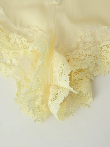 Gros plan détaillé du short en satin jaune crème avec bordure en dentelle florale délicate