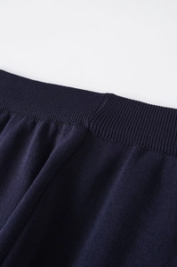 Macro shot of navy blue knitted waistline with elastic ribbed cuffs and fine stitching