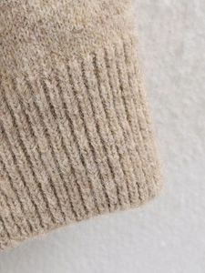 Close-up of beige ribbed knit texture and soft fuzzy fabric of the V-neck cardigan