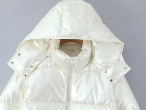 Detail of high-gloss white padded jacket collar with metal snaps and hood structure