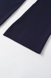 Close-up of deep blue knitted fabric showing fine texture and clean hem of the garment