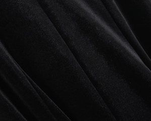 Macro shot of black velvet fabric texture showing soft luster and dense pile details