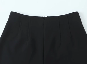 Dettaglio della vita a V nera con pince simmetriche su una gonna o un pantalone