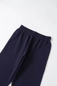 Detailed view of navy blue knitted pants featuring a soft ribbed texture and elastic waistband