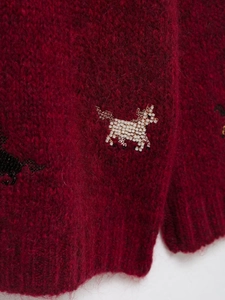 Detail of burgundy knit cardigan featuring mohair texture and white beaded horse pattern