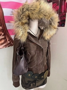 Detail of a brown corduroy jacket featuring a detachable plush faux fur collar and ribbed cuffs