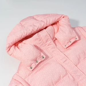 Close-up of pink hooded winter coat with white geometric prints and silver metal snaps