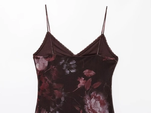 Detail of floral print camisole featuring V-neckline with delicate lace trim and thin straps